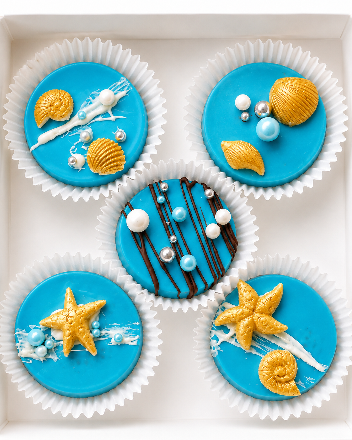 Turquoise and gold beach-themed chocolate-covered Oreos with seashells, starfish and pearls